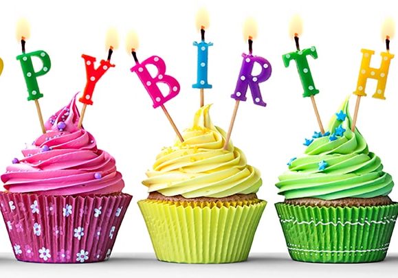 Row of colorful birthday cupcakes isolated on a white background