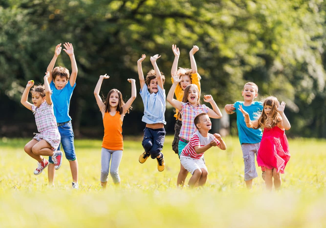 Large group of children jumping in the park and having fun.